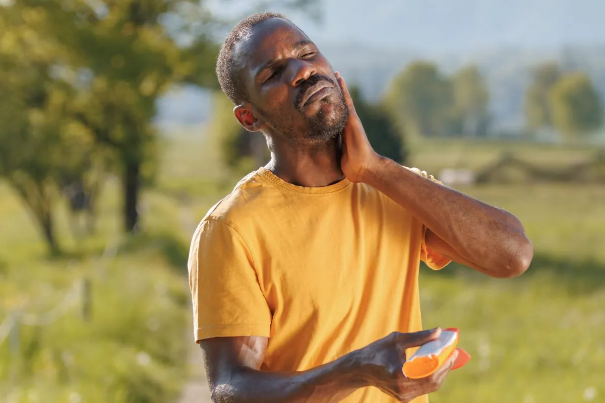 man applies sunscreen